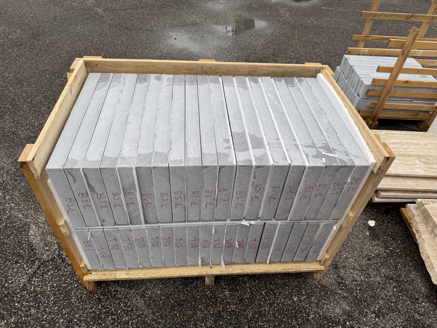 Crate of finished stone copings packed on edge in the workshop yard, ready for export