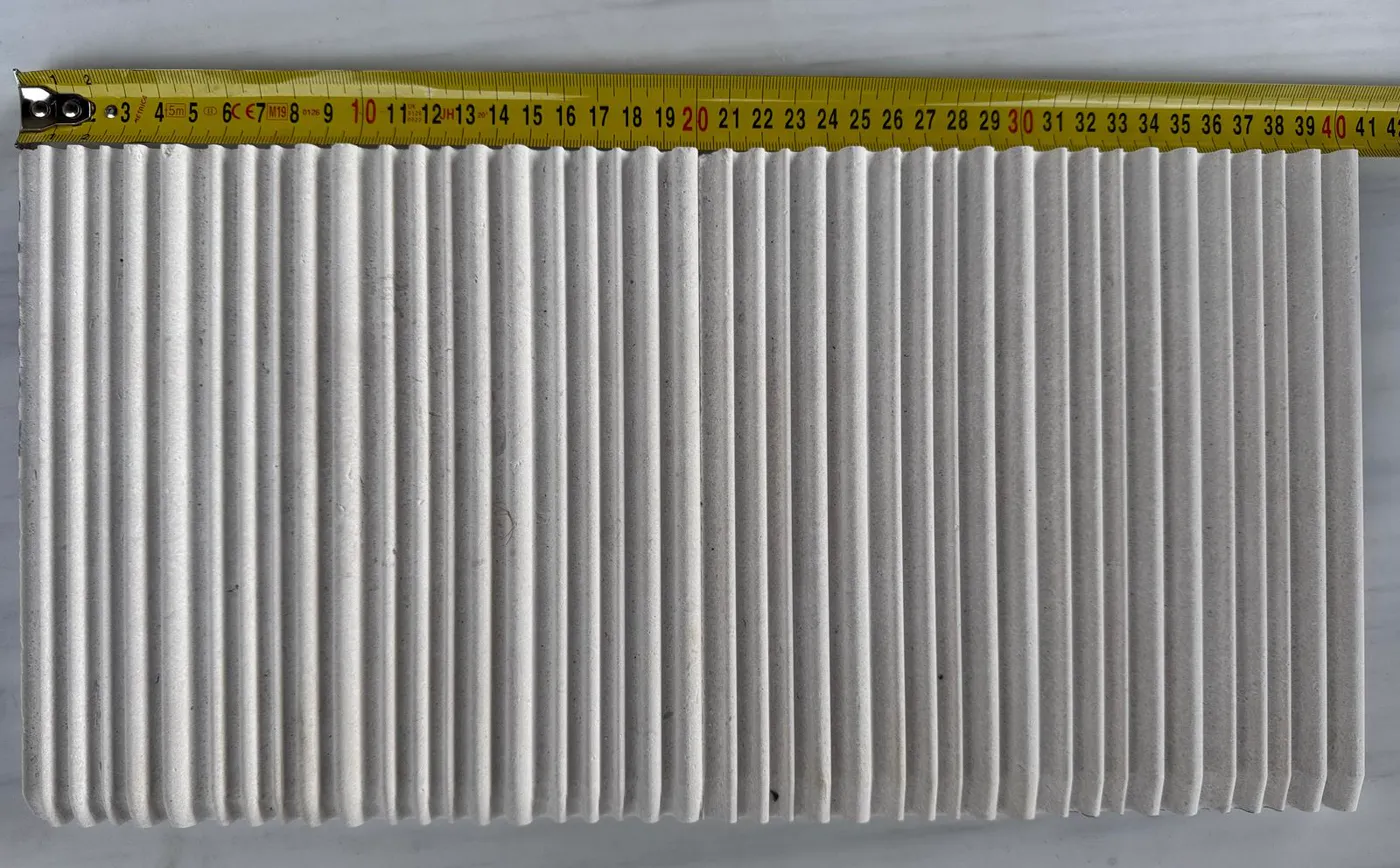 Tape measure laid across a fluted stone panel during dimensional quality control