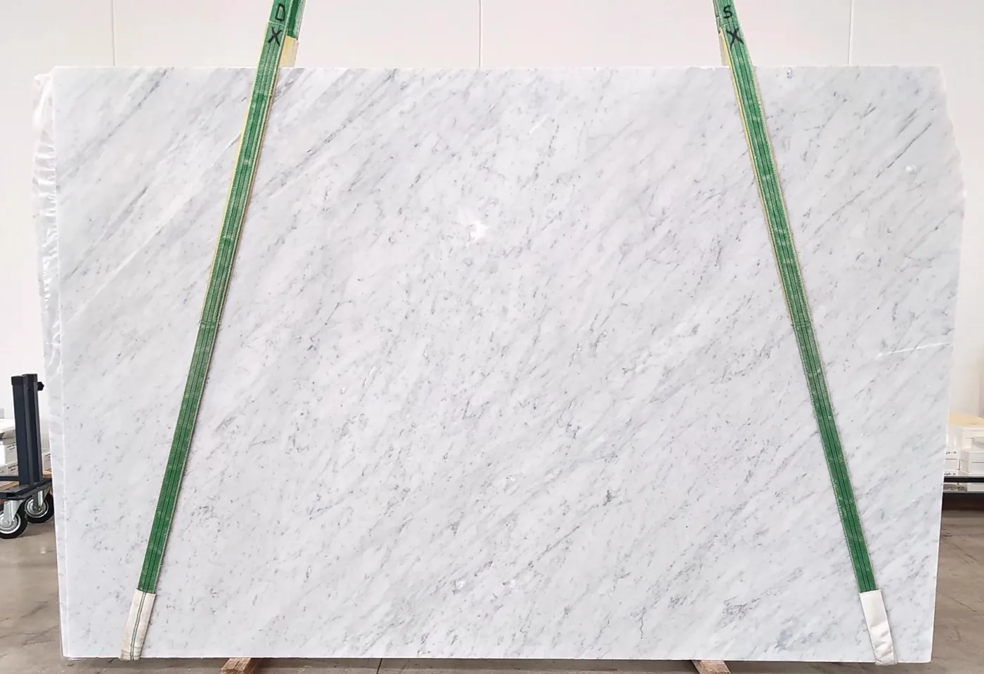 Honed white marble slab on lifting slings, tagged and photographed for approval before cutting