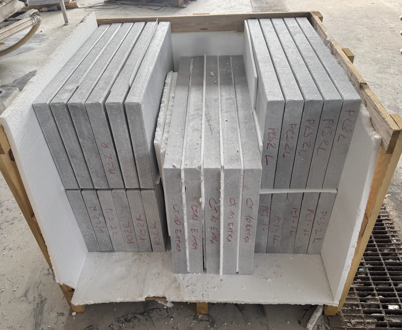 Open export crate with cut-to-size stone packed on edge and separated by foam