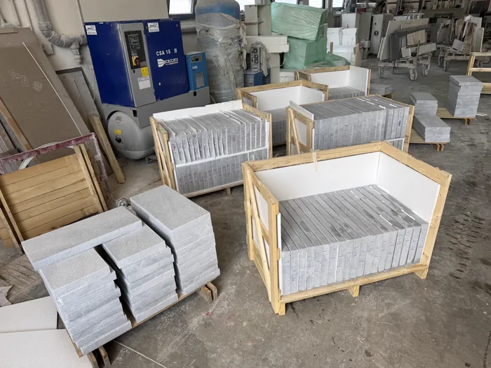 Crating hall with open wooden crates full of cut grey pieces