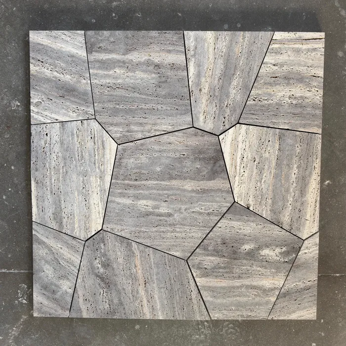 Flagstone pattern in cut stone dry-laid on the workshop floor, tight joints, before crating