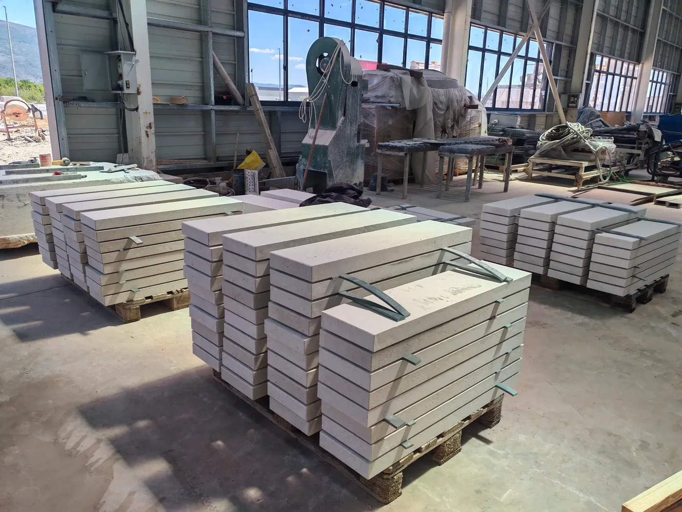 Stone workshop with pallets of solid limestone steps and copings staged for an exterior order