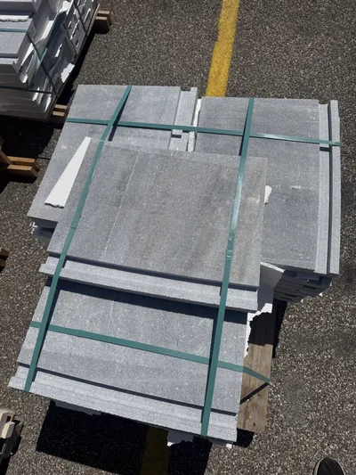 Gray stone copings strapped on a pallet in the yard, seen from above