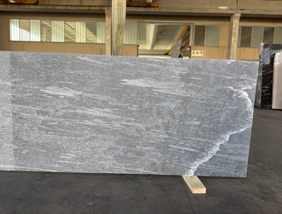 Waterflamed gray stone slab standing in the workshop hall