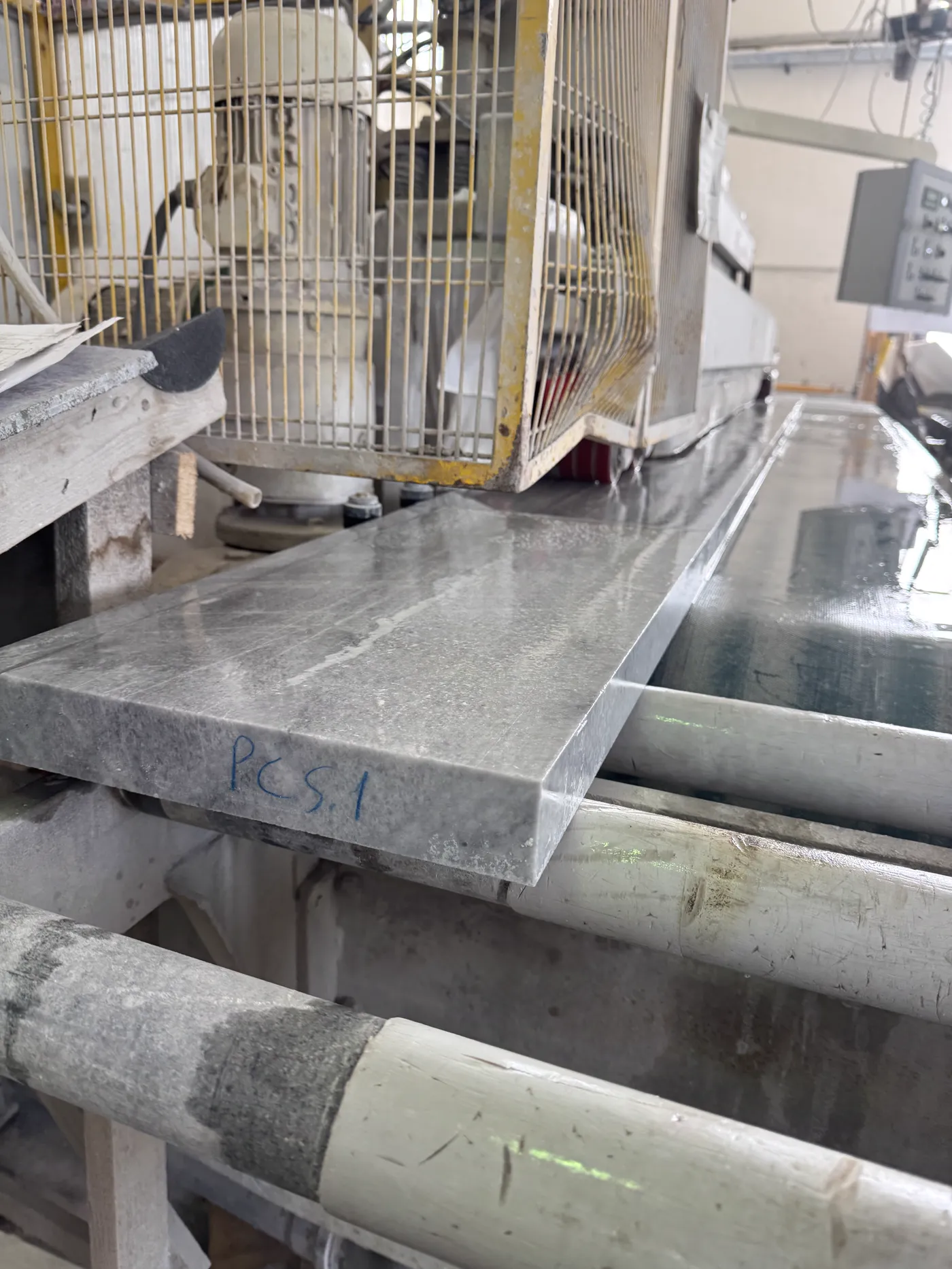 Freshly cut grey stone piece marked from the cutting list on the production line