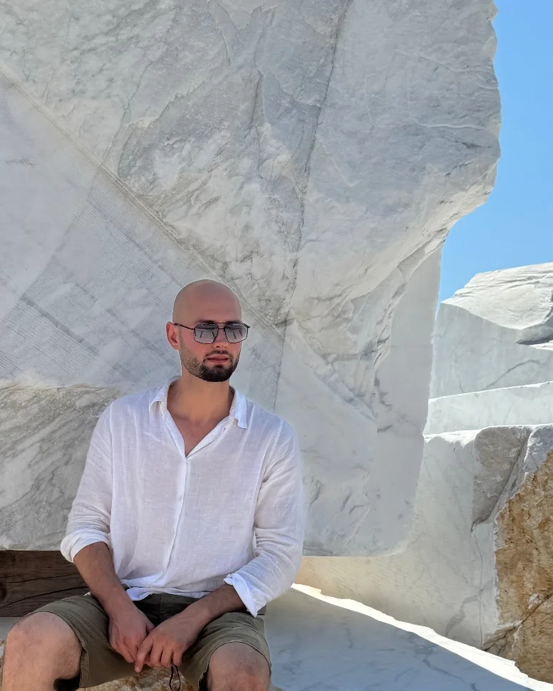 Michele Alimonta seated on white marble blocks during block selection at the quarry
