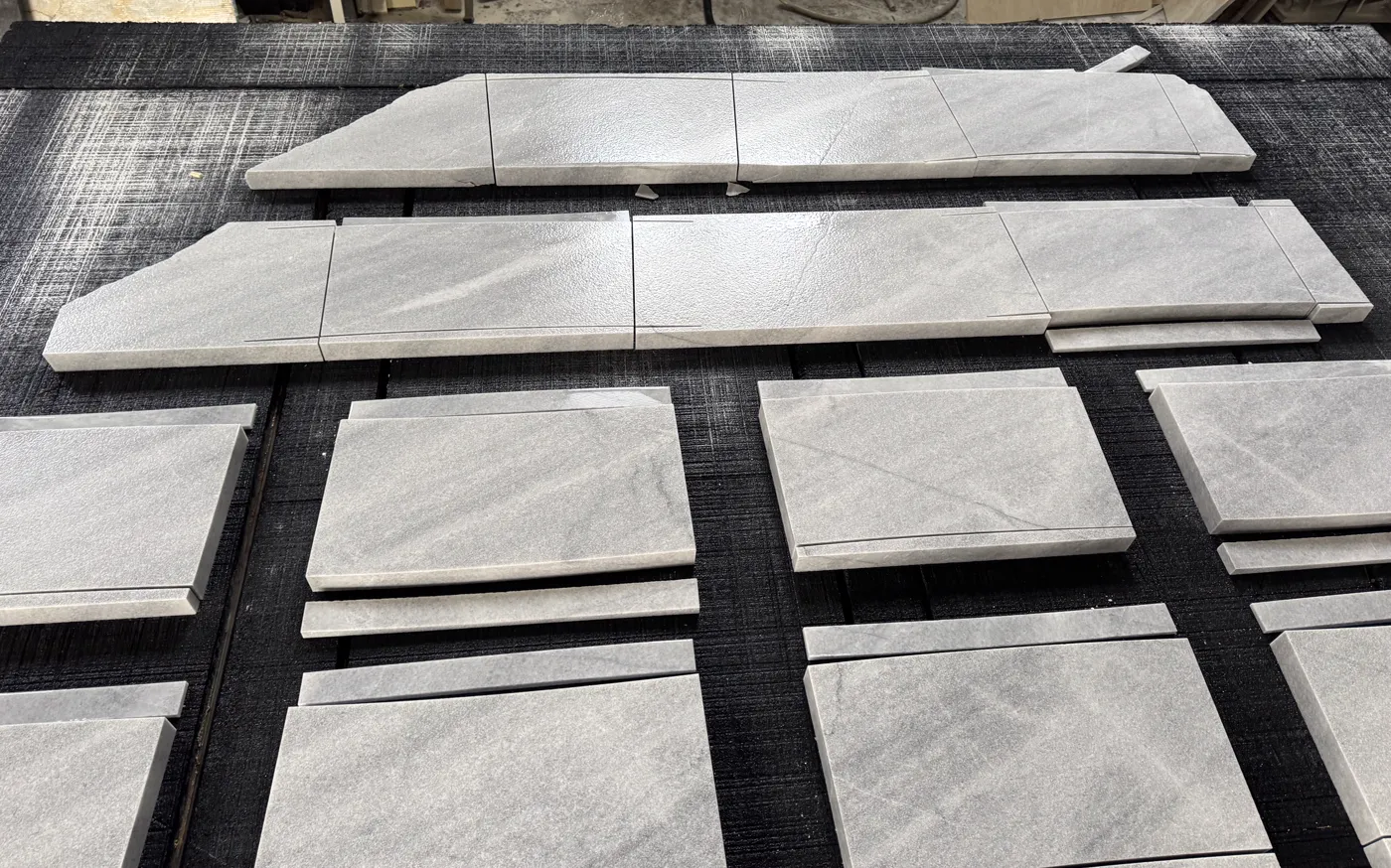 Cut-to-size stone pieces dry-laid on the shop table for a fit check