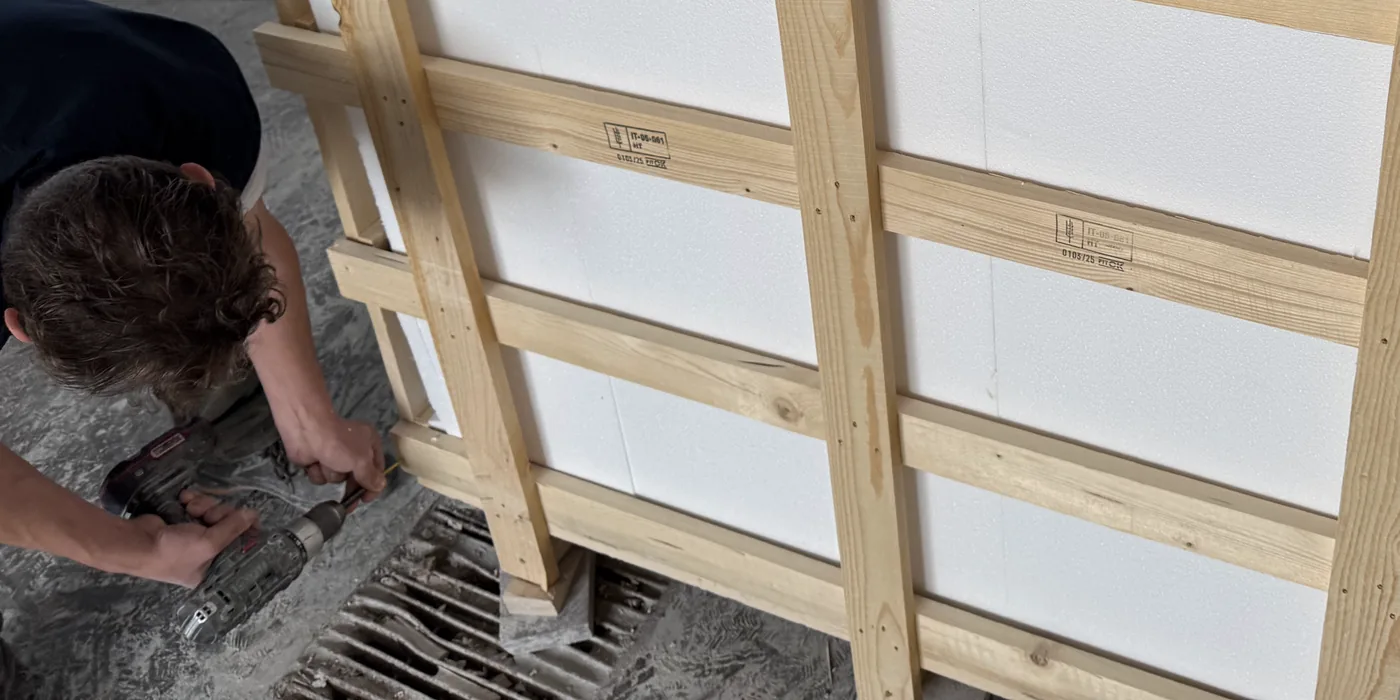 Operator driving a screw into the frame of a packed export crate