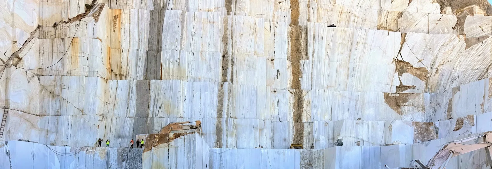 Towering white marble quarry wall in Europe, source of natural stone for Alimonta projects