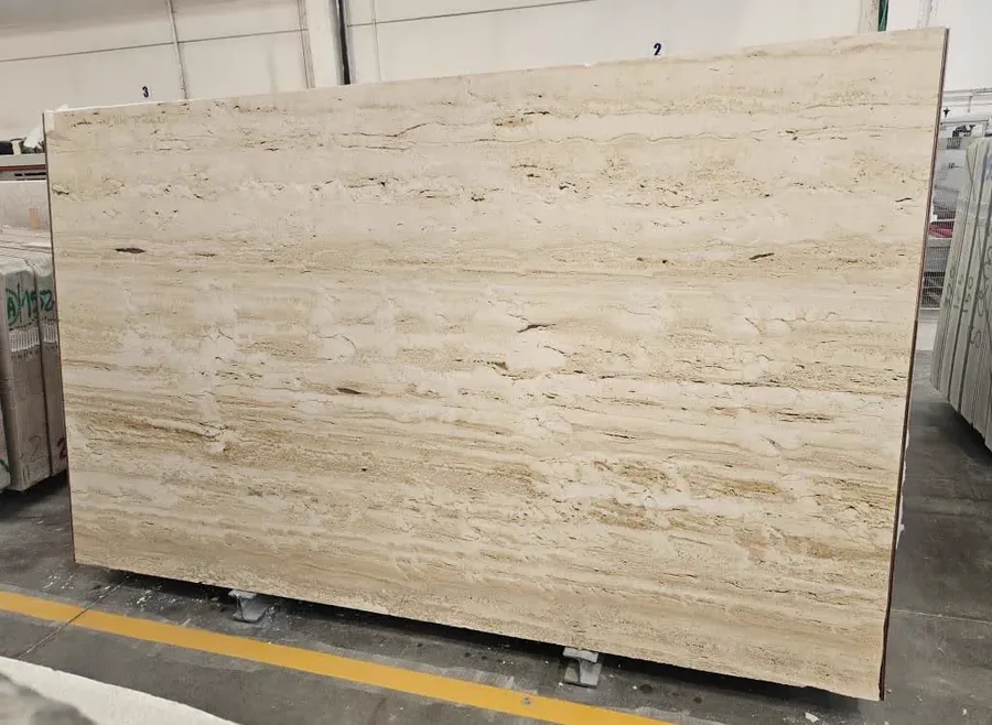 Travertino Navona slab on the rack, vein-cut with straight warm linear striations