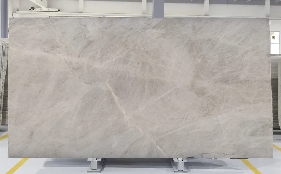 Taj Mahal quartzite slab on the rack, warm cream face with soft translucent veining