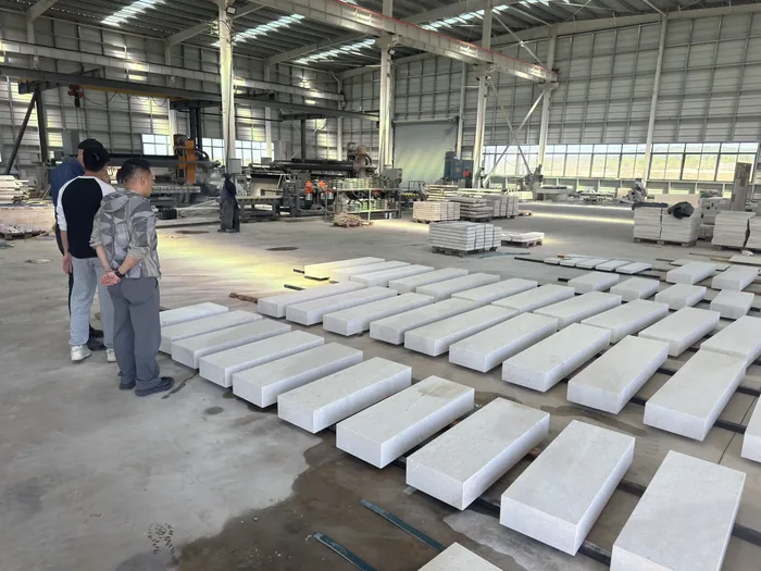 Rows of finished cut-to-size pieces on the workshop floor, two people checking them